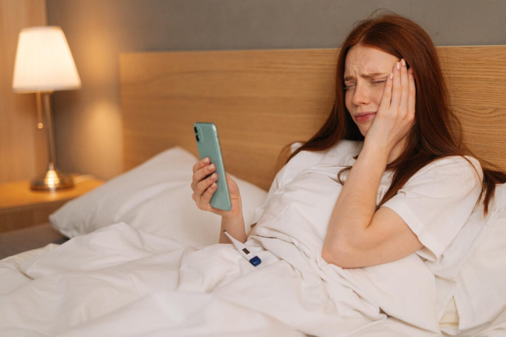 Femme se réveillant dans son lit en touchant son oreille douloureuse après une nuit de sommeil sur le côté
