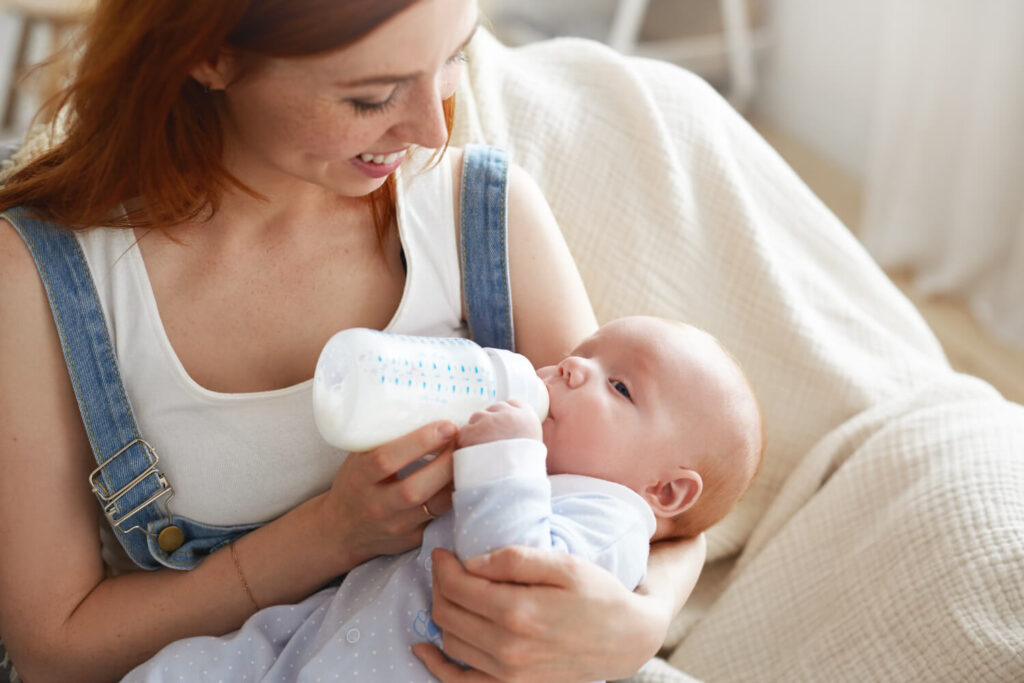 Parent préparant des biberons avec lait épaissi et lait normal pour bébé