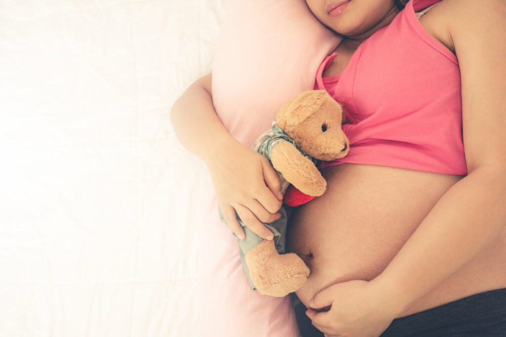 Femme enceinte touchant son ventre - mouvements du bébé et douleurs