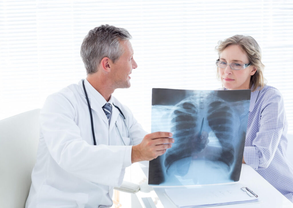 Absence de lésion pleuro-parenchymateuse : qu'est-ce que ça veut dire ? 2 Médecin expliquant à un patient une radio pulmonaire sans lésion pleuro-parenchymateuse évolutive.