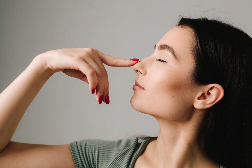 Profil d'une personne qui touche son nez
