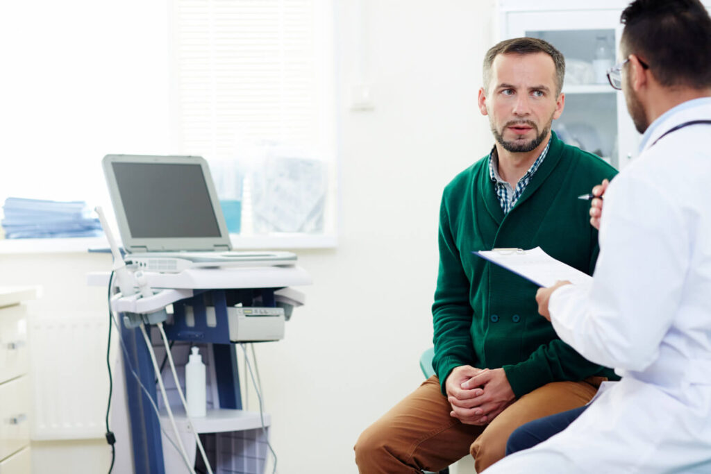 Anéjaculation : causes, symptômes et traitements 1 Homme consultant un médecin pour un problème d'anéjaculation, illustrant les causes et les traitements possibles.