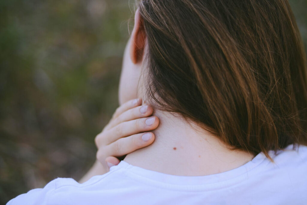 Bouton derrière la nuque : quelle est sa signification ? 7 Gros plan sur un bouton douloureux derrière la nuque, pour en comprendre la signification.