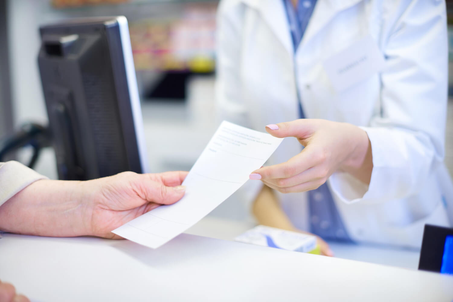 Gros plan sur les mains d'un médecin rédigeant un certificat médical sur son bureau, illustrant la démarche de déclaration pour un contrat de prévoyance.