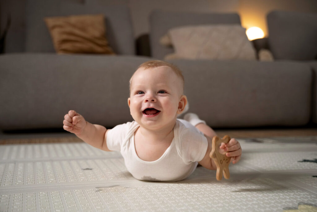 Mon bébé met ses bras en arrière : est-ce normal ? 2 Bébé sur le ventre mettant ses bras en arrière en position "avion", illustrant un comportement moteur normal.