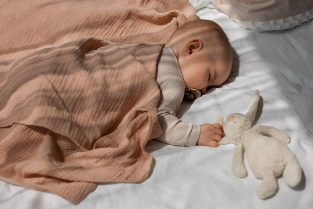Mon bébé n'aime pas la gigoteuse : que faire ? 5 Bébé dormant paisiblement dans un surpyjama, une alternative pour un bébé qui n'aime pas la gigoteuse.