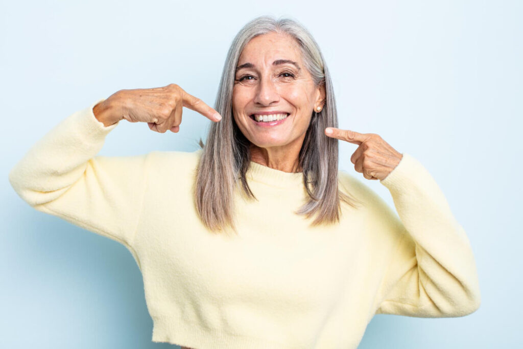 Mon dentier bouge quand je mange : que faire ? 2 Personne souriant avec confiance, illustrant les solutions pour un dentier qui bouge quand on mange.