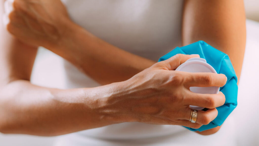 Douleur et gonflement après une prise de sang : normal ? 2 Personne appliquant une compresse froide sur un bleu après une prise de sang pour soulager la douleur et le gonflement.