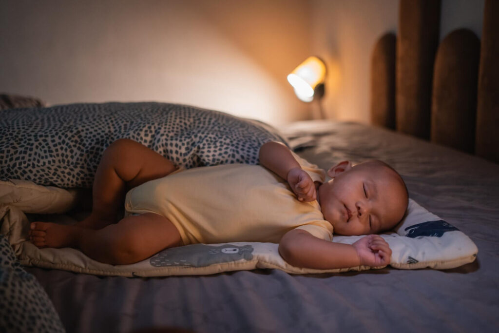 Mon bébé de 3 mois commence sa nuit à 18h : que faire ? 2 Bébé de 3 mois dormant paisiblement, illustrant un coucher très tôt à 18h.