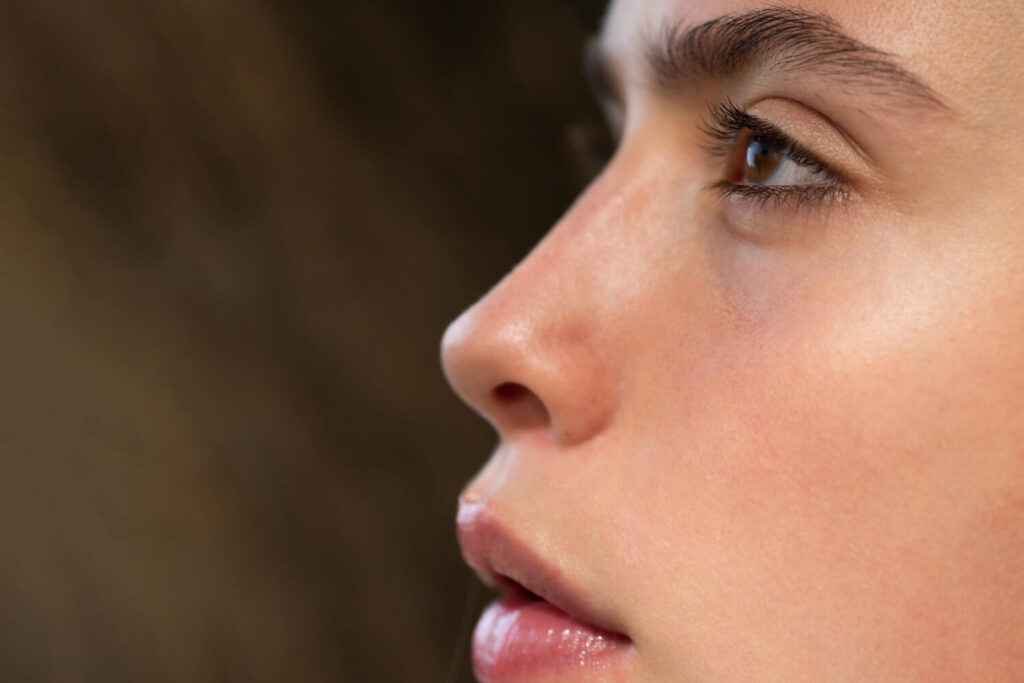 Un mini poil sur le nez : c'est quoi et que faire ? 6 Gros plan sur la peau d'un nez montrant un mini poil ou duvet, expliquant les causes et solutions.