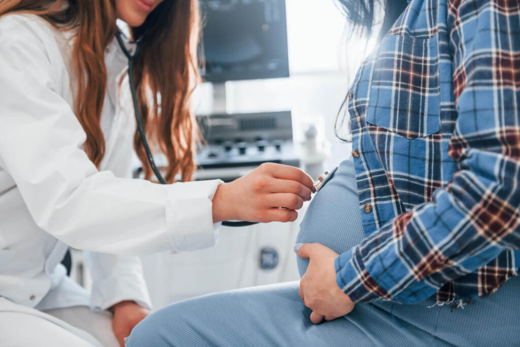 Trop de liquide amniotique (hydramnios) : Témoignage 2 Professionnel de santé mesurant le ventre d'une femme enceinte pour surveiller un excès de liquide amniotique (hydramnios)