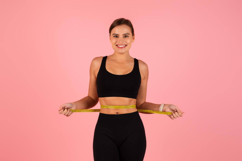 Comment affiner sa silhouette en 15 jours ? 2 Femme mesurant son tour de taille, illustrant un programme pour affiner sa silhouette en 15 jours.