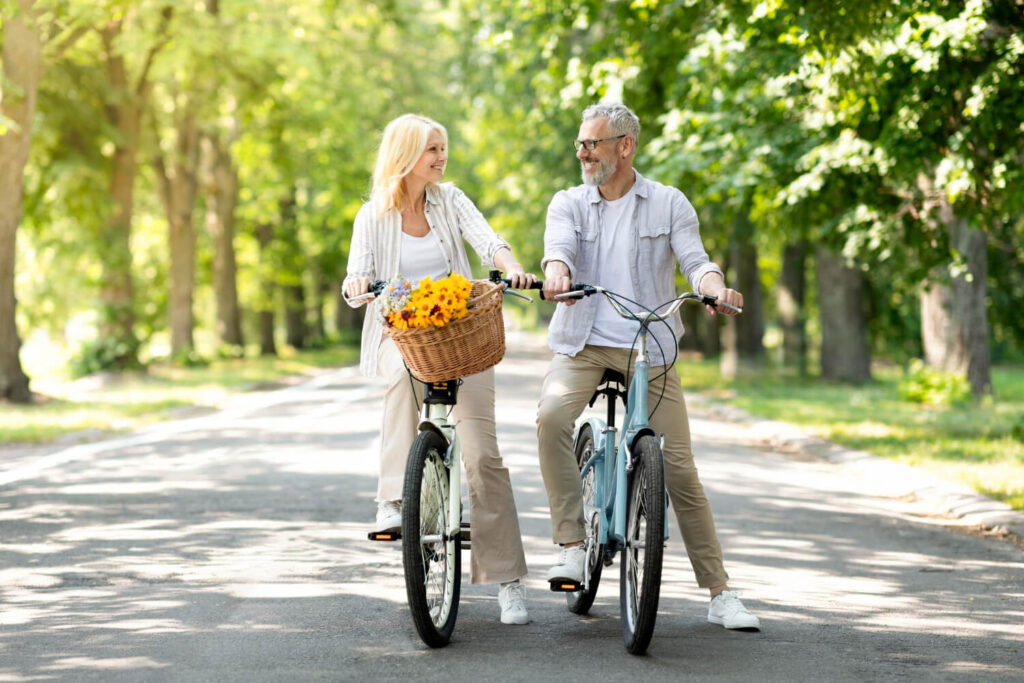 Quelle vitesse moyenne à vélo à 70 ans ? 2 Couple de 70 ans faisant du vélo sur une piste cyclable, pour savoir quelle est une bonne vitesse moyenne.
