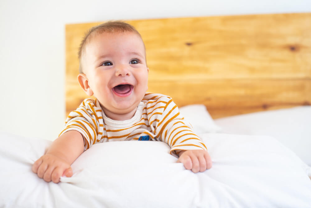 Mon bébé secoue sa tête de gauche à droite rapidement : jeu, sommeil ou inquiétude ? 3 Bébé souriant dans son lit qui tourne la tête de gauche à droite.