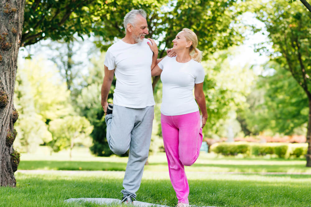 Comment préserver son capital santé après 60 ans sans se ruiner ? 7 Couple de séniors dynamiques pratiquant la marche en pleine nature pour rester en forme.