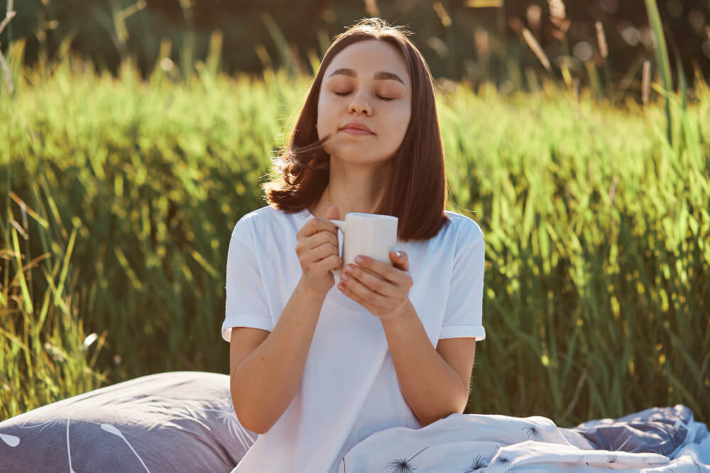 Une personne sereine profitant d'un moment de relaxation en plein air, évoquant les bienfaits du bien-être au quotidien.