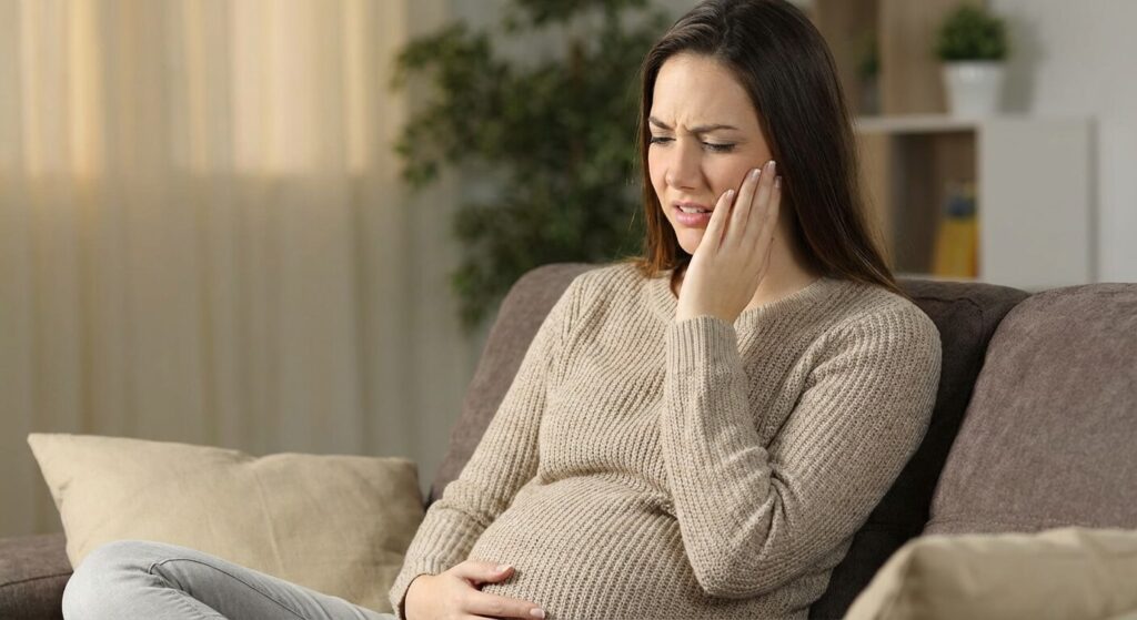 Femme enceinte souffrant d'une douleur dentaire aiguë et se tenant la joue