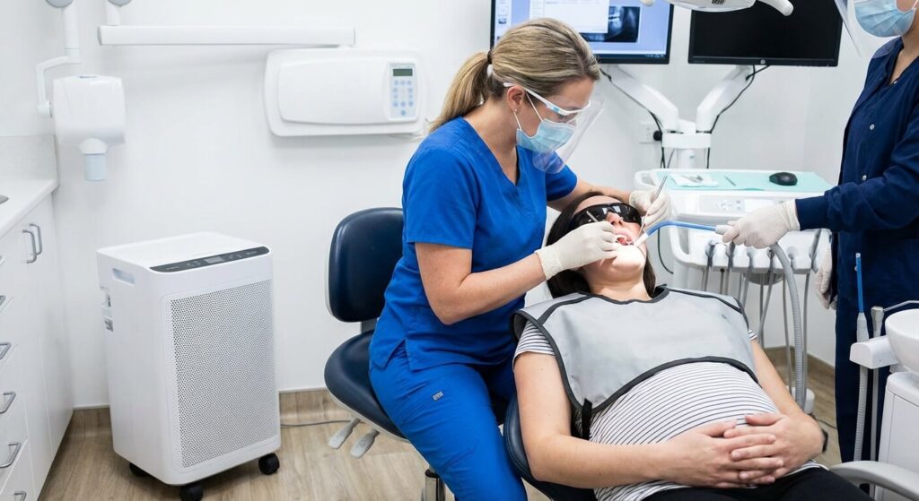 Dentiste effectuant un soin d'urgence sur une patiente enceinte avec toutes les précautions de sécurité