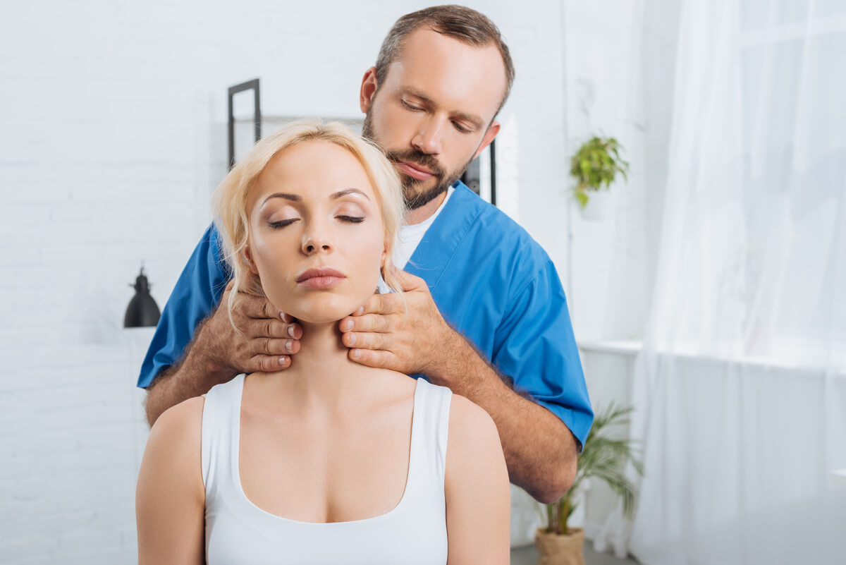 Kinésithérapeute professionnel massant avec précaution les muscles de la région cervicale