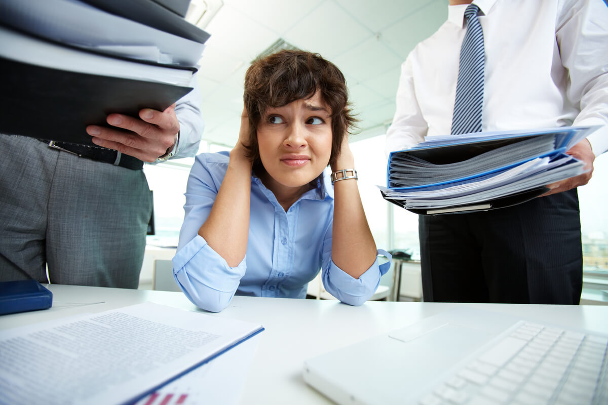 Une salariée en état d'épuisement professionnel consultant son dossier pour trouver des solutions face au refus d'arrêt.