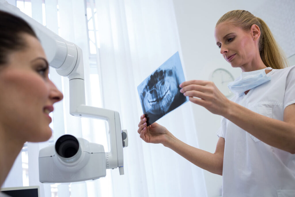 Un chirurgien-dentiste analysant une radiographie panoramique avant la pose d'implants.