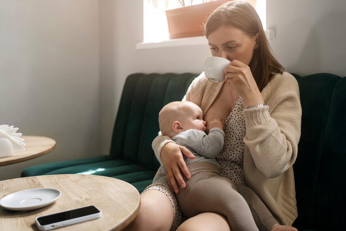 Une maman qui allaite doucement son bébé la nuit dans la pénombre d'une chambre.