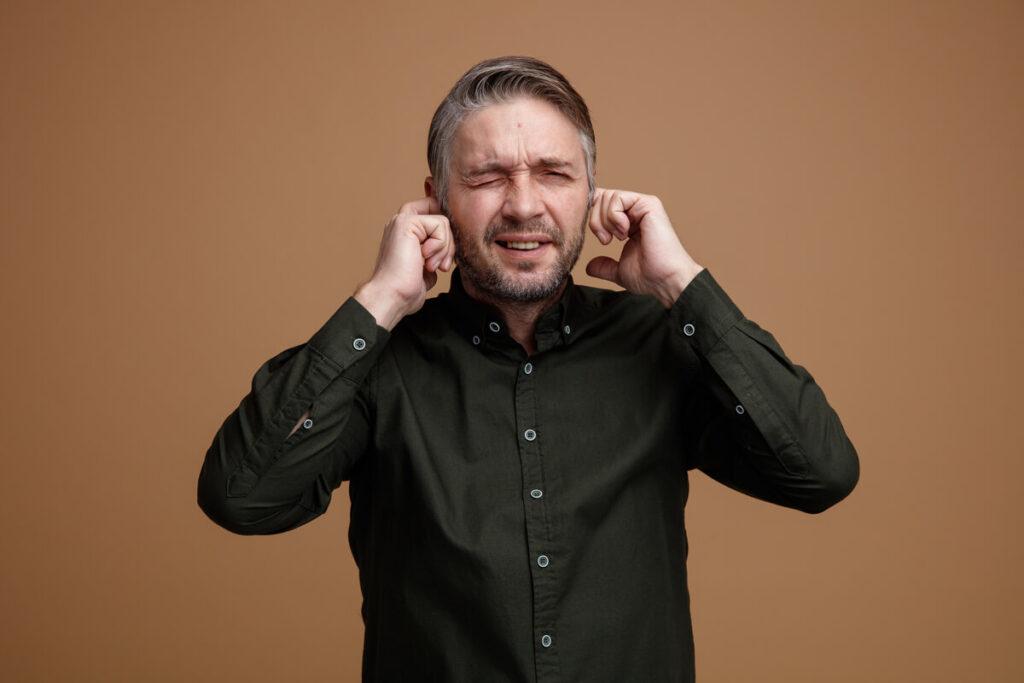 Mettre des Boules Quies avec une otite : risques, dangers et bonnes pratiques 2 Une personne ressentant une douleur à l'oreille et hésitant à utiliser une protection auditive.