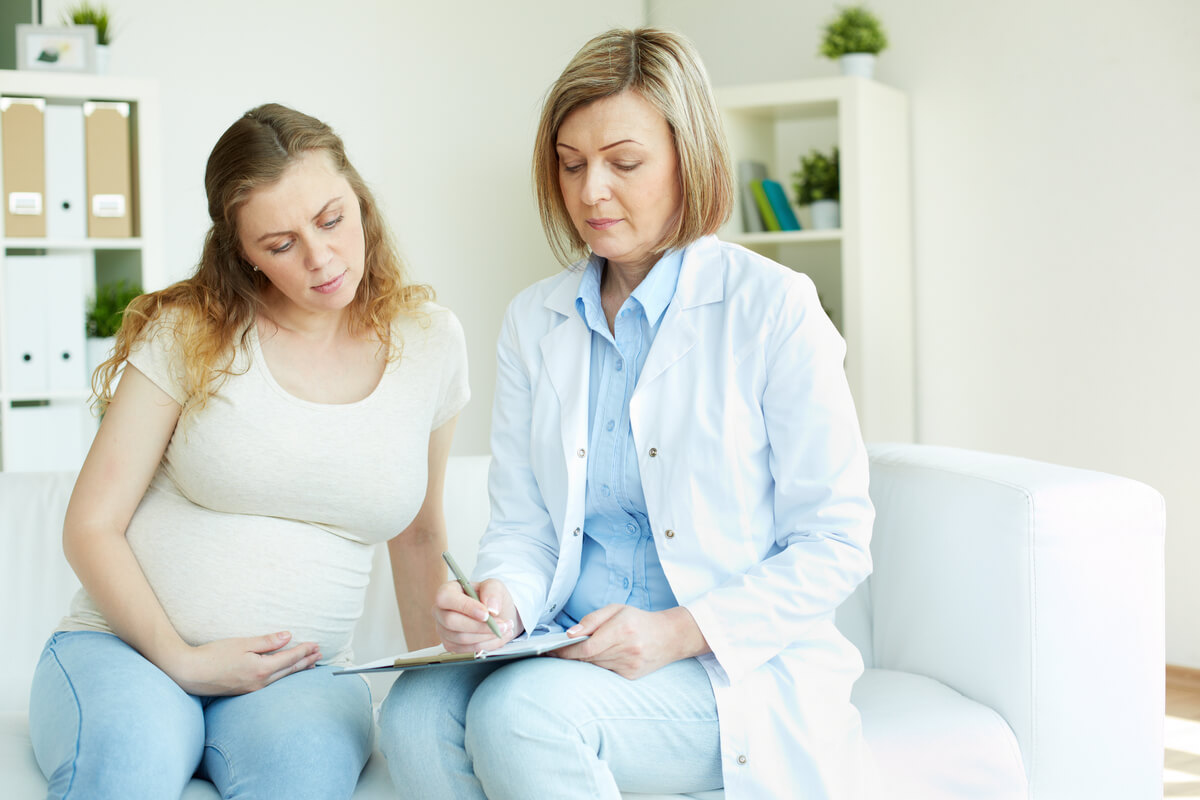 Une jeune femme qui échange un regard rassurant avec sa sage-femme en consultation.