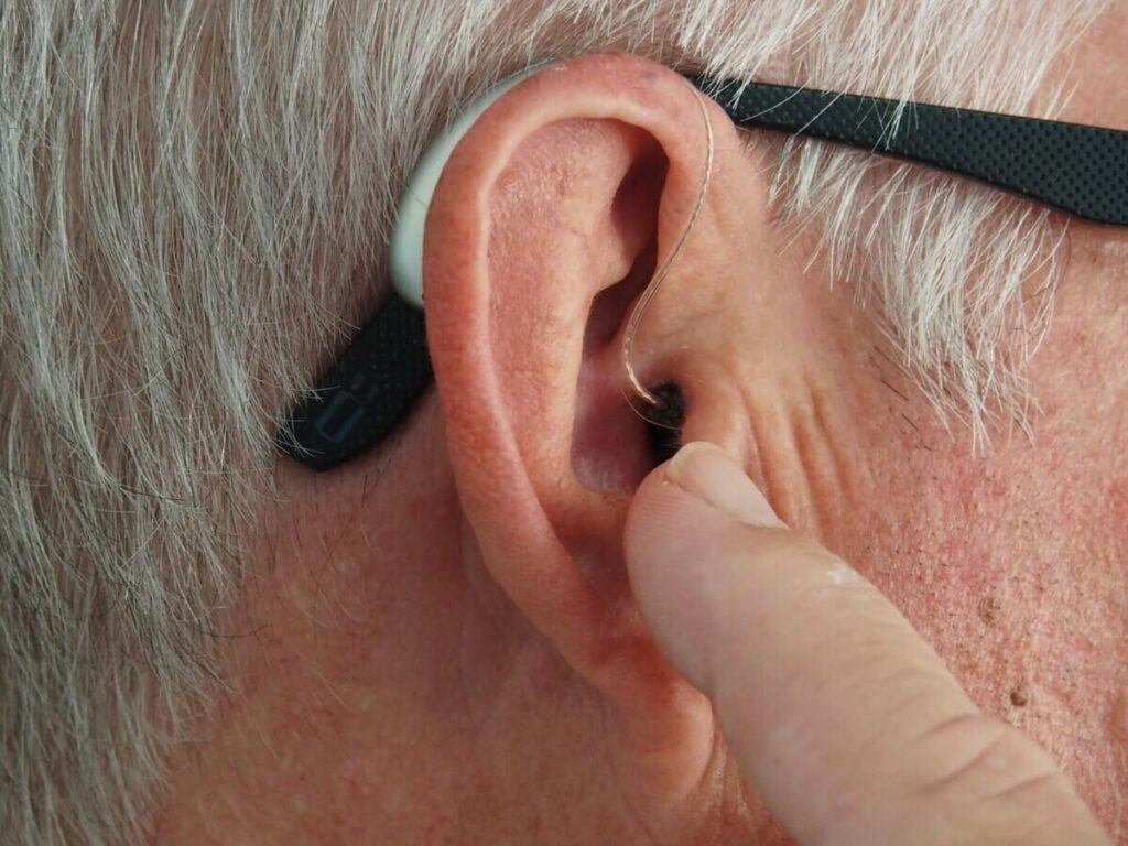Perte auditive avec l’âge : quand faut-il consulter un audioprothésiste ? 2 Une aide auditive moderne et intra-auriculaire très discrète placée dans le conduit d'une oreille.