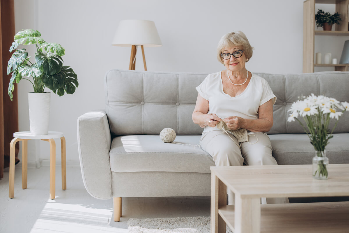 Un salon lumineux aménagé pour un senior, avec un mobilier ergonomique et des espaces de circulation dégagés.