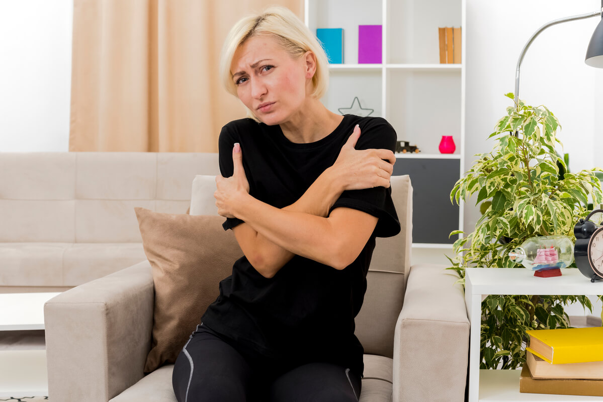 Une personne ressentant des tressauts musculaires involontaires au niveau du bras à cause de l'anxiété.
