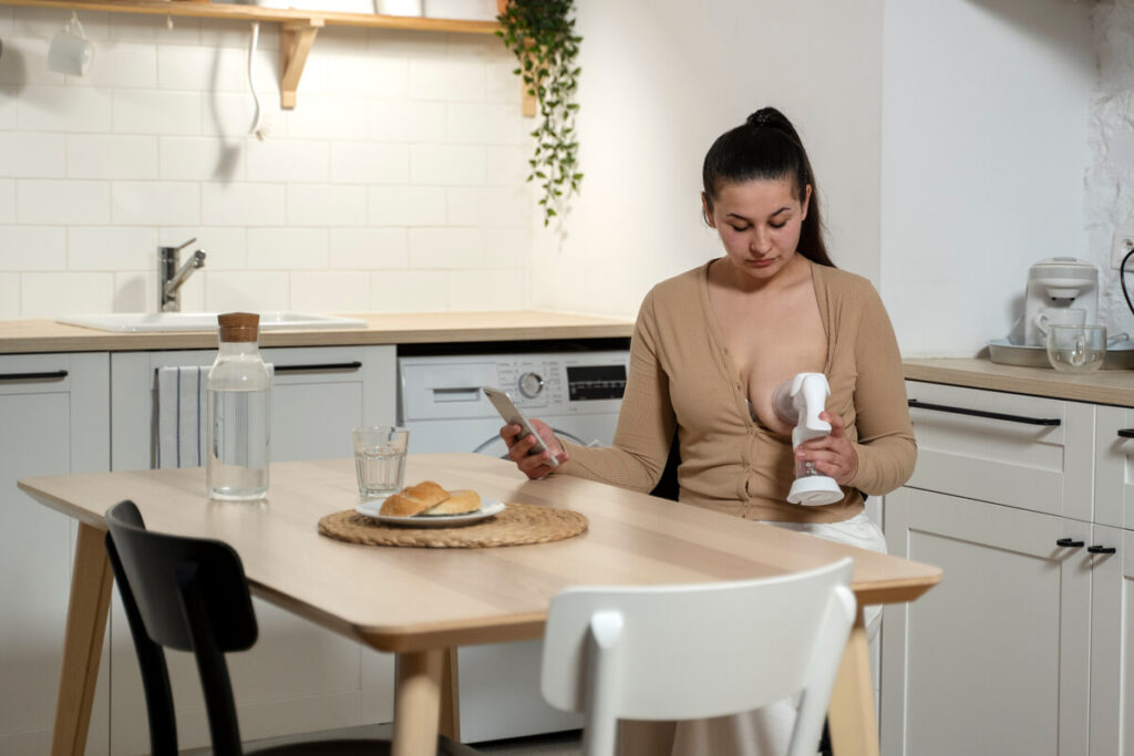 Comment épaissir le lait maternel en cas de reflux ? 2 Une maman qui prépare un biberon de lait maternel dans sa cuisine avec soin.
