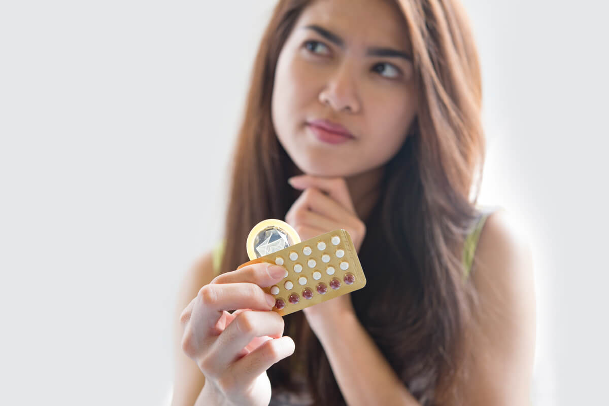 Une plaquette de pilules contraceptives tenue dans la main pour rappeler l'importance de la prise quotidienne régulière.