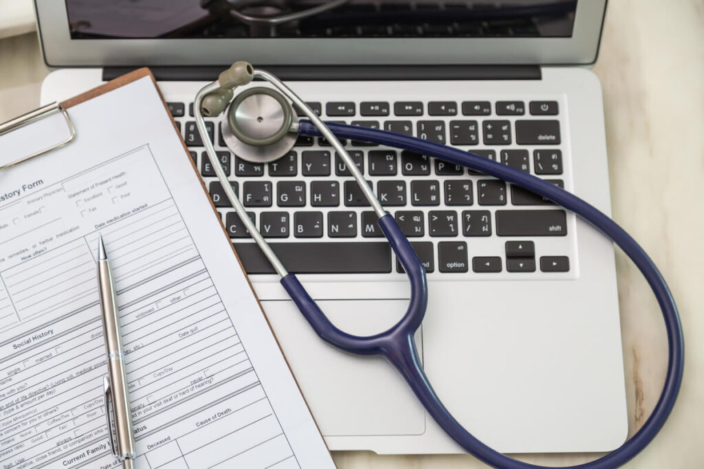 Une stéthoscope posé sur des dossiers médicaux secrets dans un cabinet de consultation propre.