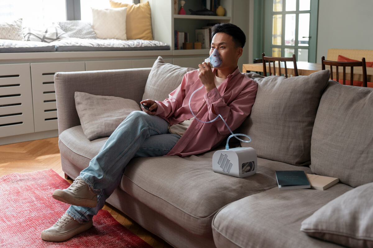 Un appareil concentrateur d'oxygène médical installé à côté d'un lit à la maison.