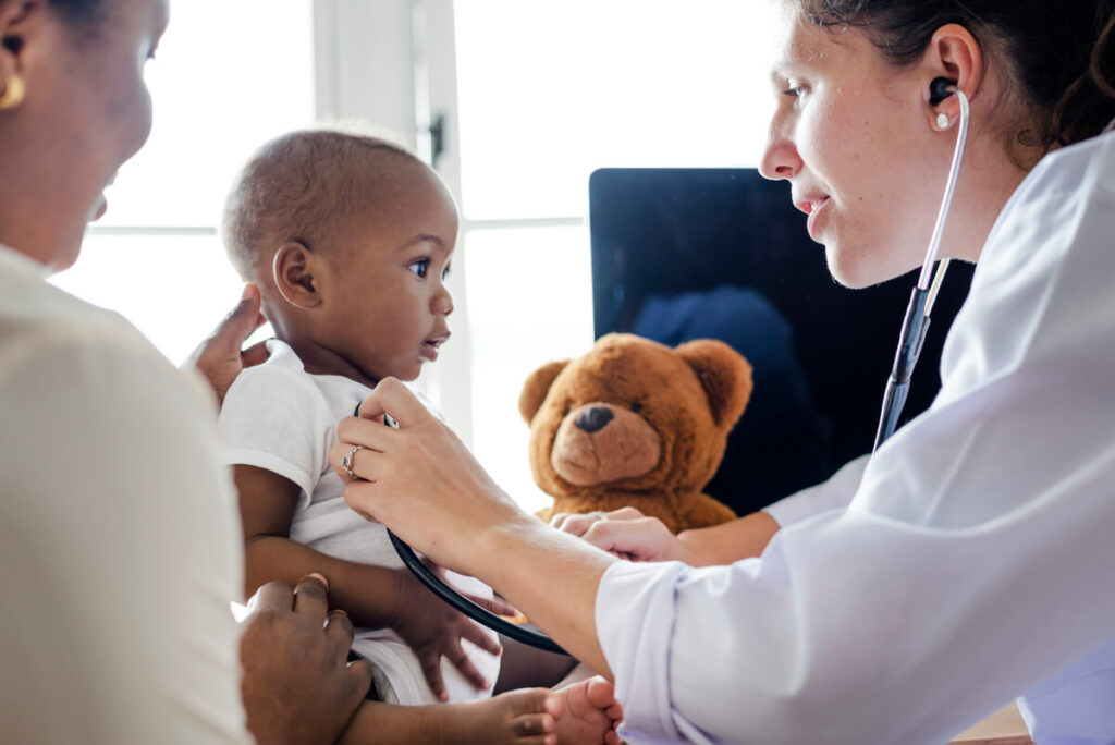 Vaccin BCG et bouton avec du pus : est-ce une réaction normale ? 3 Un pédiatre examinant calmement un nourrisson lors d'une visite médicale de contrôle.