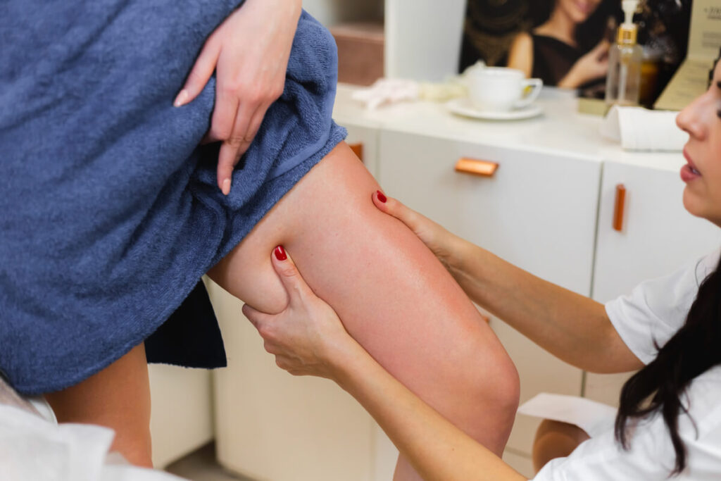 Un médecin phlébologue examinant la circulation veineuse des jambes d'un patient lors d'une consultation.