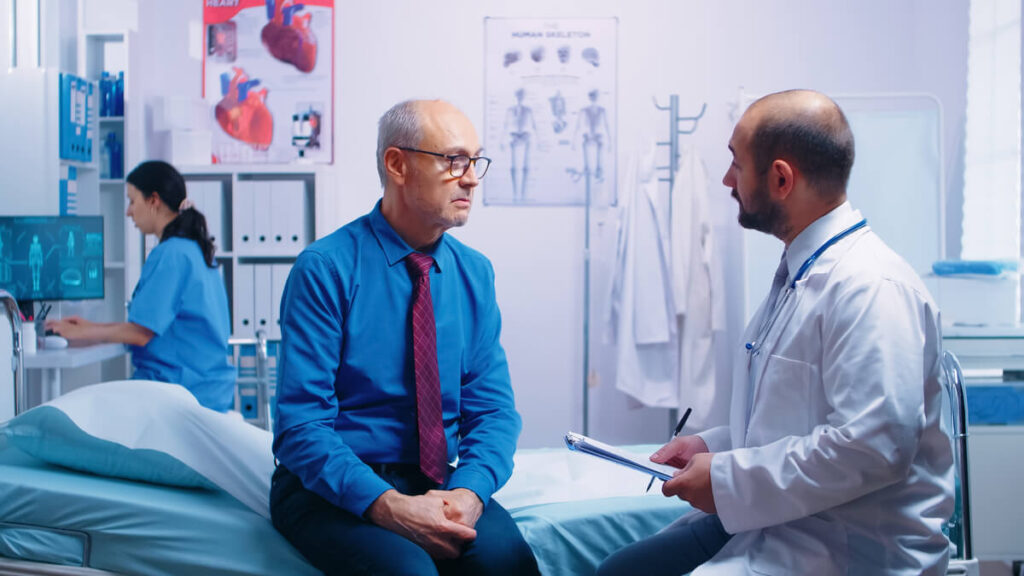 Un urologue expliquant les étapes du bilan urodynamique à un patient rassuré.