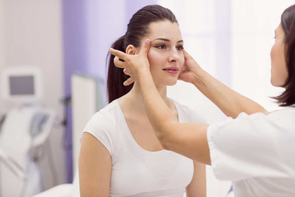 Dijon : l'importance du diagnostic médical en esthétique 2 Un médecin esthétique analysant la peau du visage d'une patiente lors d'une consultation à Dijon.