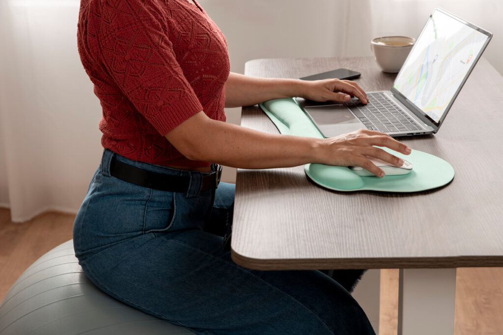 Une employée installée sur un siège ergonomique adapté pour soulager les pressions sur le plancher pelvien.