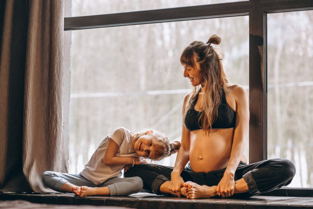 Une jeune maman effectuant un exercice de respiration douce sur un tapis de yoga pour renforcer son centre.