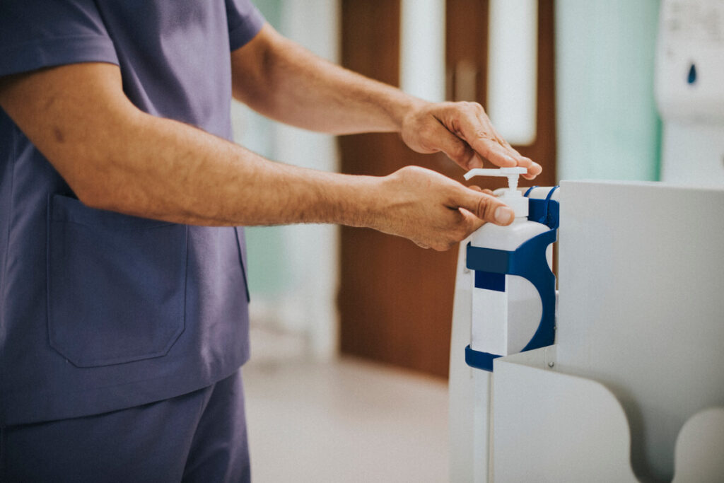 Réglementation et loi sur le port de l'alliance en milieu hospitalier 2 Un infirmier se frictionnant les mains à l'aide d'une solution hydro-alcoolique à l'hôpital.