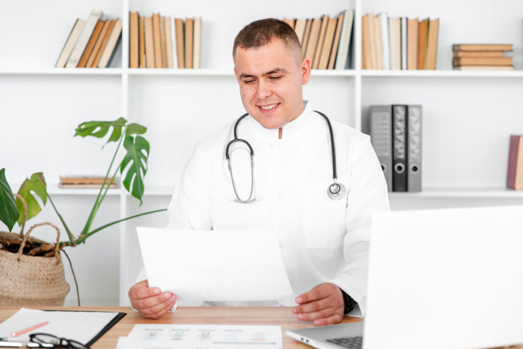 Un professionnel de santé en blouse blanche signant son contrat d'assurance professionnelle à son bureau.