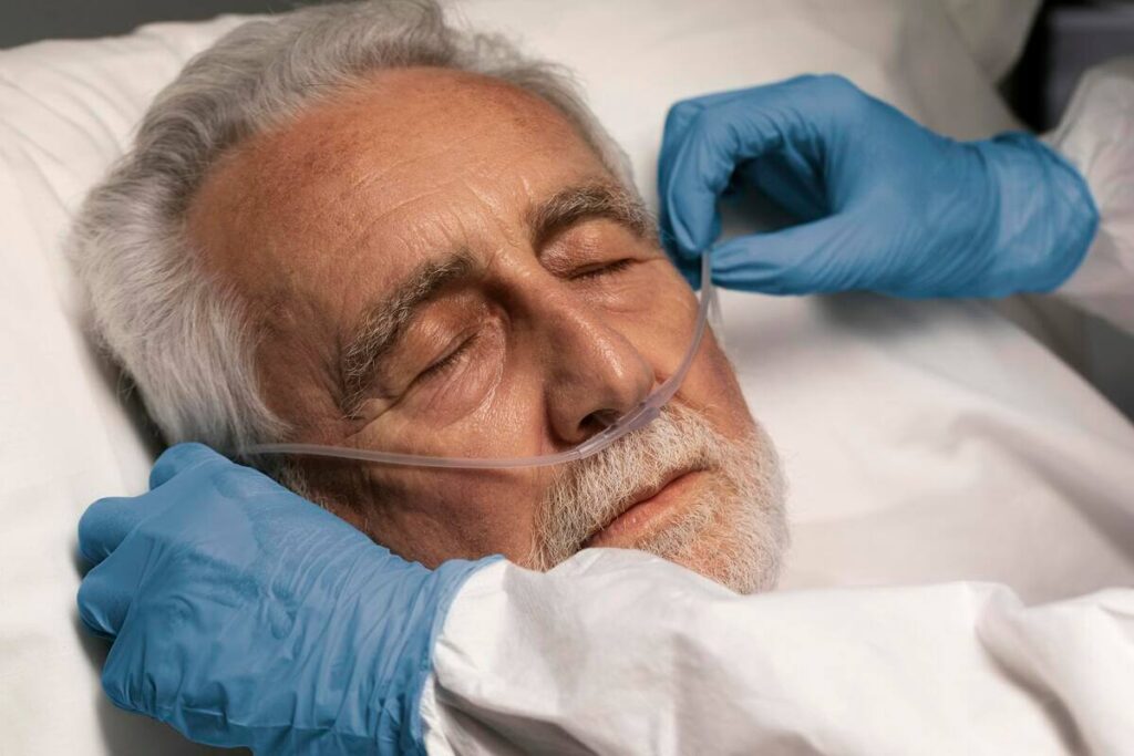 Une personne âgée se reposant calmement avec des lunettes à oxygène transparentes sous le nez.