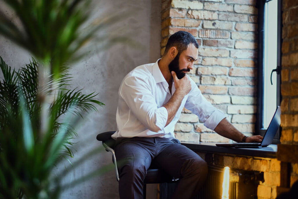 Un homme actif en tenue professionnelle travaillant sereinement au bureau sans gêne au quotidien.