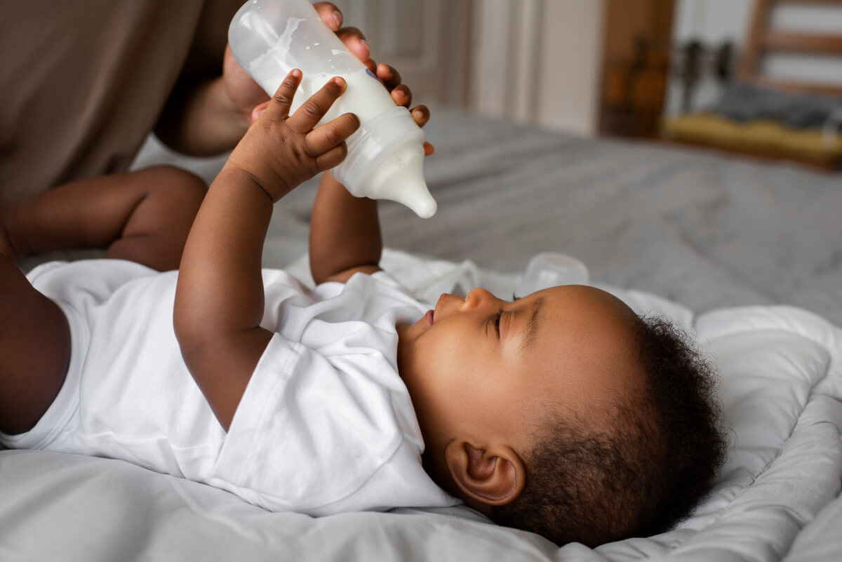 Biberon de lait infantile entamé posé sur une table après un repas de bébé.