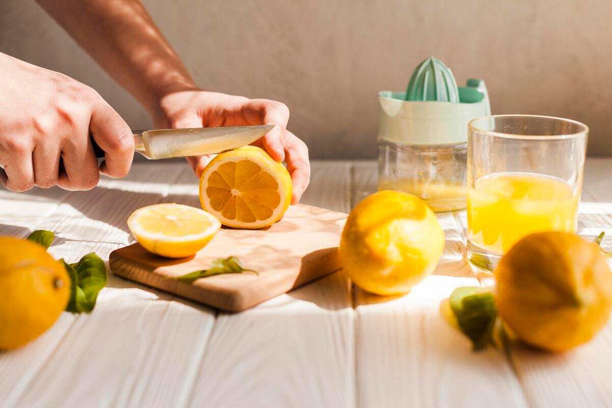 Verre de jus de citron pressé et boîte de comprimés de cortisone sur une table.