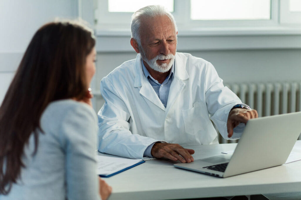 Hématies élevées dans les urines et fatigue : causes, examens et traitements 3 Médecin analysant un bilan rénal et des résultats sanguins avec son patient.