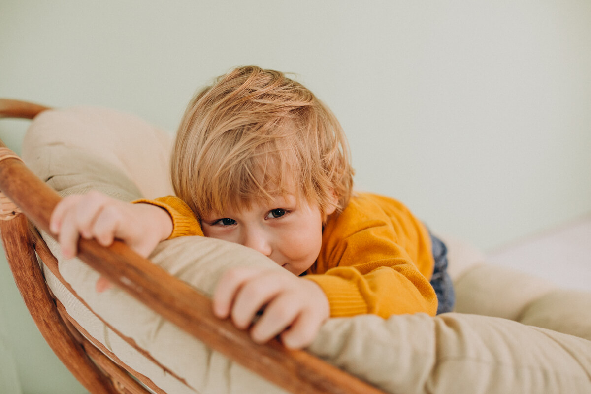 Petit garçon de 2 ans assis dans son lit à barreaux pleurant au réveil de la sieste.