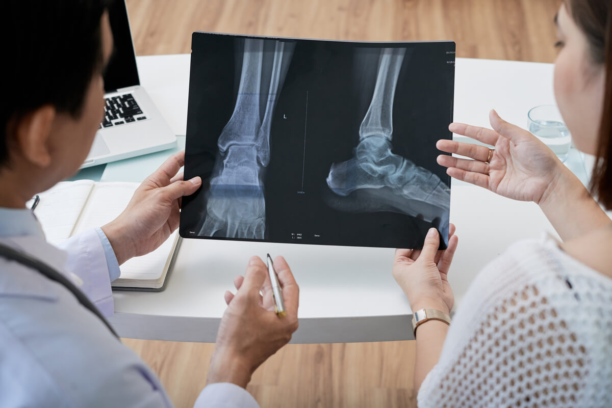 Manipulateur en radiologie installant un patient pour une radiographie de la cheville.